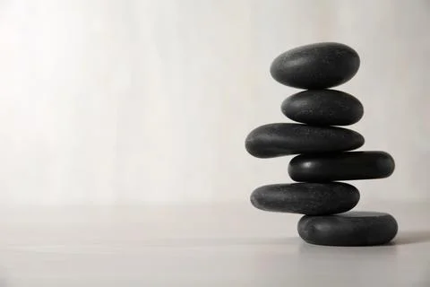 Stack of black spa stones on light background. Space for text 스톡 사진