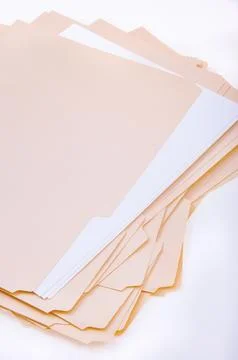 Stack of blank beige file folders arranged haphazardly Stock Photos