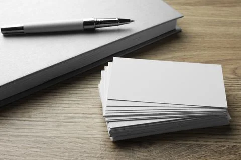 Stack of blank business cards, notebook and pen on wooden table. Mockup for.. Stock Photos