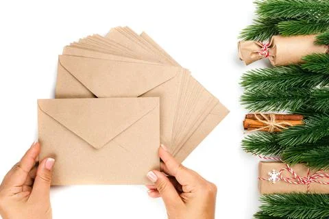 Stack of blank craft envelopes in woman hands for New Year greetings to family 写真素材