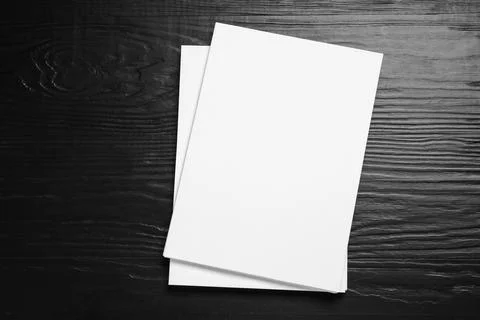 Stack of blank paper sheets for brochure on black wooden background, top view Stockfoto's