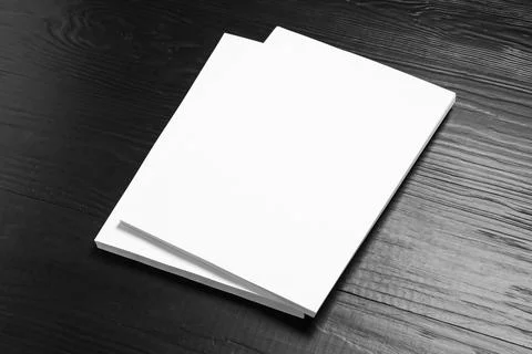 Stack of blank paper sheets for brochure on black wooden background. Mock up 스톡 사진