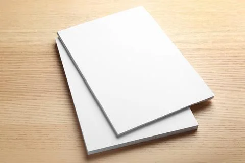 Stack of blank paper sheets for brochure on wooden background. Mock up Stockfoto's