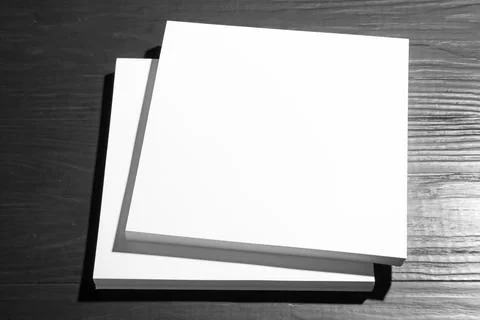 Stack of blank paper sheets for brochure on black wooden background. Mock up Stock Photos