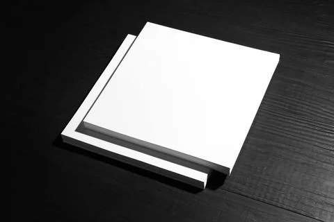 Stack of blank paper sheets for brochure on black wooden background. Mock up Stock Photos