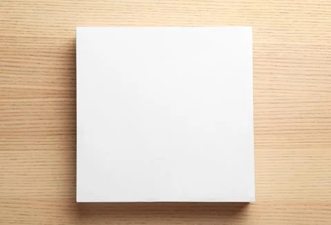 Stack of blank paper sheets for brochure on wooden background, top view. Mock Stock Photos