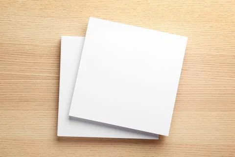 Stack of blank paper sheets for brochure on wooden background, top view. Mock Foto stock