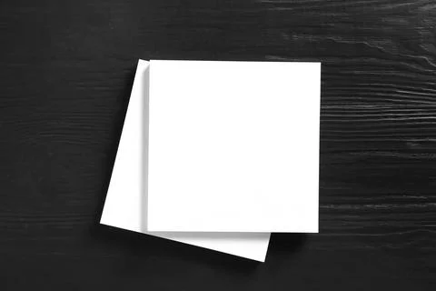 Stack of blank paper sheets for brochure on black wooden background, top view Foto stock