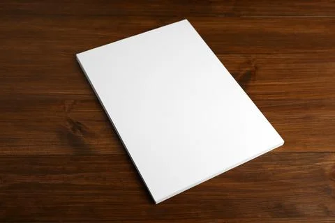 Stack of blank paper sheets on wooden table. Brochure design Stockfoto's