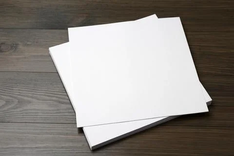 Stack of blank paper sheets on wooden table. Brochure design Stock Photos