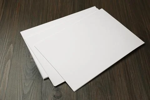 Stack of blank paper sheets on wooden table. Brochure design Stock Photos