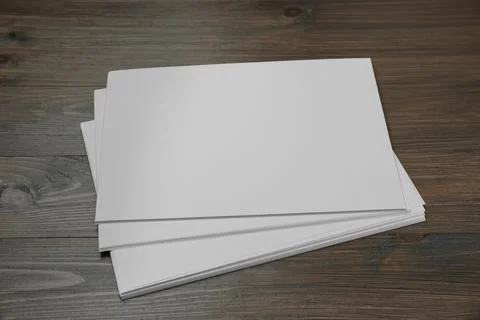 Stack of blank paper sheets on wooden table. Brochure design Foto stock