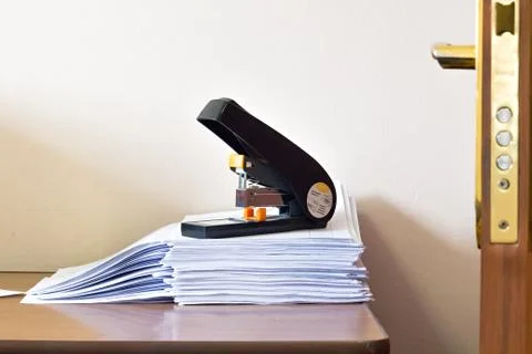 Stack of blank white paper with big office stepler Stock Photos