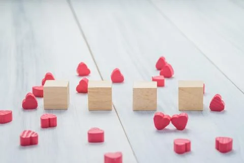 Stack of blank wood cube with group of mini red heart on white rustic table t Stock Photos