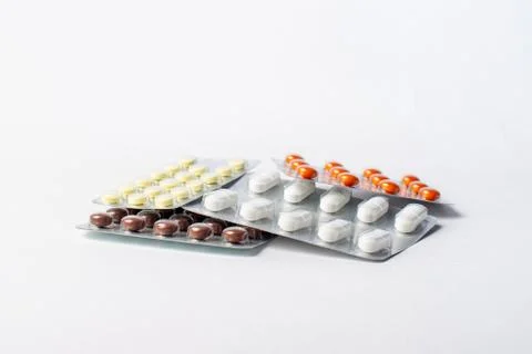 A stack of blisters with color pills on a white background Stock Photos