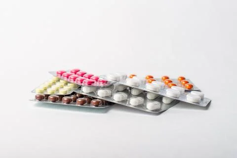 A stack of blisters with color pills on a white background Stock Photos