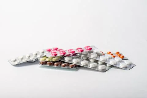 A stack of blisters with color pills on a white background Stock Photos
