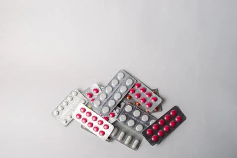 A stack of blisters with color pills on a white background. Flat lay, top vie Stock Photos