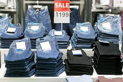 Stack of blue and black jeans in a shop. Stock Photos