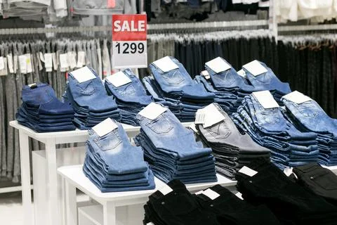 Stack of blue and black jeans in a shop. Stock Photos