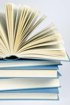 A stack of blue books on light blue background Stock Photos