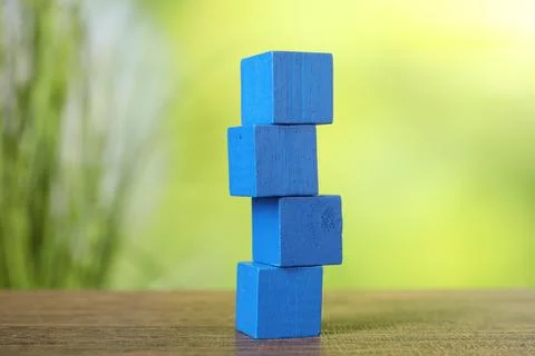 Stack of blue cubes on wooden table against blurred background Stockfoto's