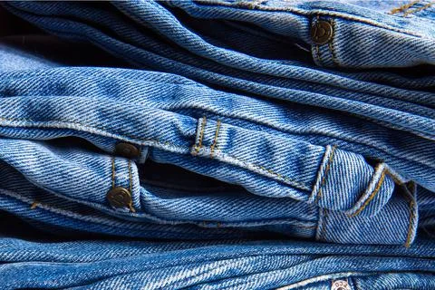 Stack of blue jeans. Abstract background. Draped background of classic jeans  Stock Photos