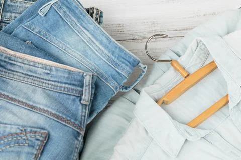Stack of blue jeans and denim shirt on hanger Stock Photos