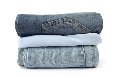Stack of blue jeans isolated on white background, space for text, close-up Stock Photos
