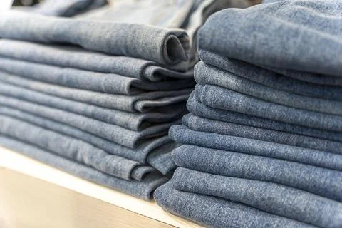 A stack of blue jeans on a shelf in the store. fashion clothing store Stock-Fotos