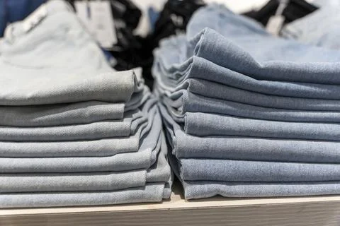 A stack of blue jeans on a shelf in the store. fashion clothing store Stock-Fotos
