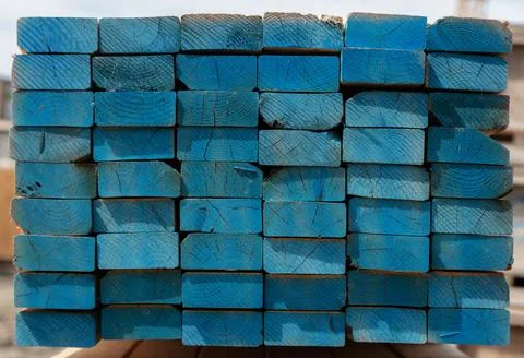 Stack of blue painted lumber planks, fresh sawn timber pile end view Stock Photos
