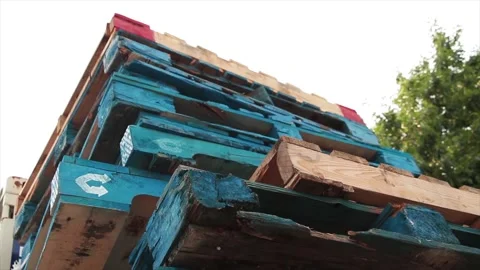 Stack of blue palettes skids on top of one another with wood colored ones too Stock Footage 246611525