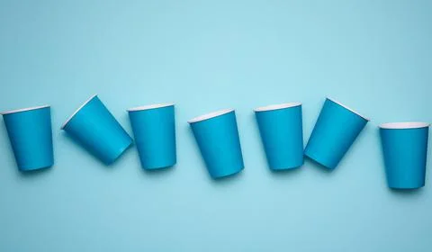 Stack of blue paper cups on a blue background. Plastic rejection concept, zer 库存照片