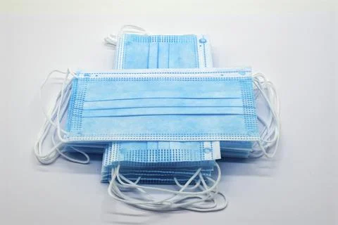 Stack of blue surgical masks on white surface Foto stock