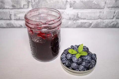 A stack of blueberries with a jar of blueberry jam Stock Photos