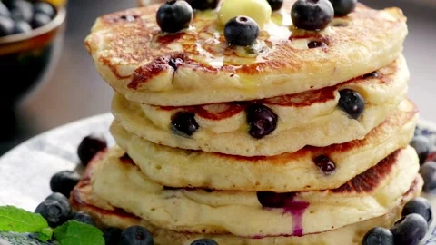 Stack of Blueberry Pancakes with Butter and Maple Syrup. Pancakes with berries. Vídeo Stock 336589270