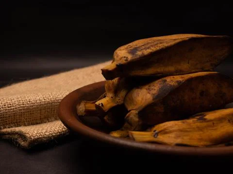 Stack of boiled bananas on a round pottery plate Stock Photos