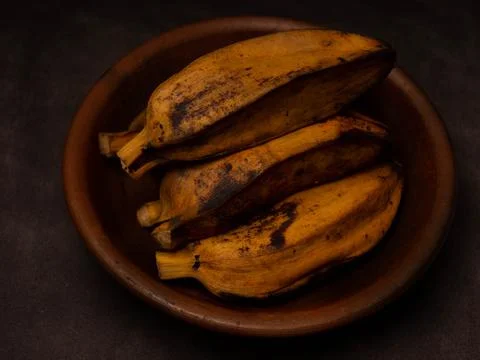 Stack of boiled bananas on a round pottery plate Stock Photos