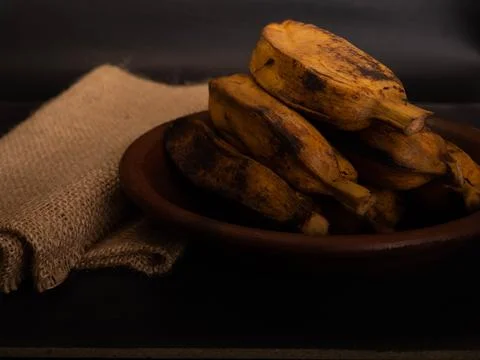 Stack of boiled bananas on a round pottery plate Stock Photos
