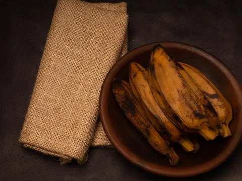 Stack of boiled bananas on a round pottery plate Stock Photos