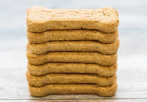 Stack of Bone shaped dog biscuits of brown color. Dog food used for training Stock Photos