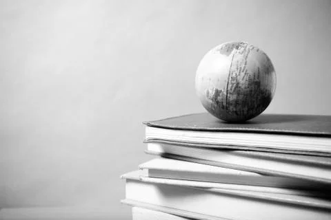 Stack of book and earth ball black and white tone style Stock Photos