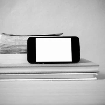 Stack of book and smart phone black and white color tone style Stock Photos