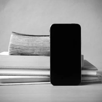 Stack of book and smart phone black and white color tone style Stock Photos