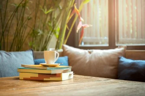 Stack of book with coffee cup on top on wooden table Stock Photos
