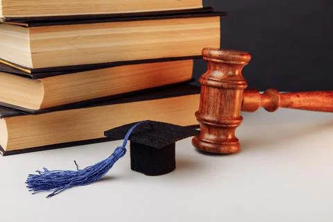 Stack of books, academic cap and wooden gavel Stock Photos