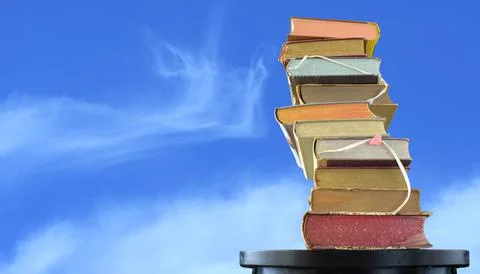 Stack of books against cloudy sky, inspiration,reading, education, literature Stock Photos