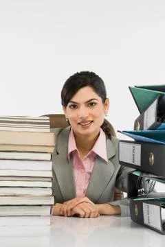 Stack of books and binders in front of a businesswoman at desk Fotos Stock