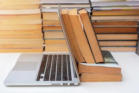 Stack of books and a computer on the table Stock Photos
